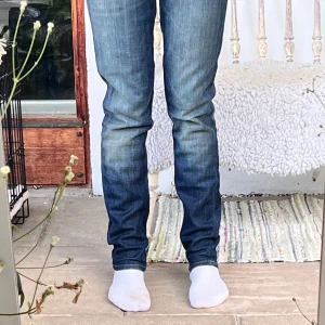 Lee Lynn Skinny jeans blå W29 L33 - Snygga Lee Lynn Skinny jeans i mörkblå tvätt med slitningar och skinny fit. Klassisk femficksmodell med dragkedjegylf och smal passform hela vägen ner. Perfekta för dig som gillar en tajt look och vill ha jeans med lite edge.