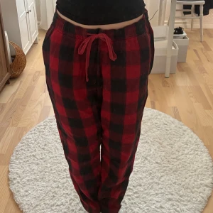 Rödrutiga mjukisbyxor Abercrombie XL - Röda och svarta rutiga pyjamas byxor från Abercrombie & Fitch i storlek XL. Byxorna har resår i midja samt vid ankeln. Mjukt och skönt tyg. 
