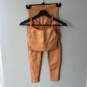 Träningskläder kit från ICANIWILL - Säljer ett par orangea seamless leggings från ICANIWILL med hög midja och tight passform tillsammans med matchande sporttopp i storlek S