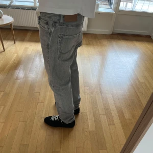 Relaxad jeans ifrån Jack and Jones - Säljer ett par gråa relaxed jeans ifrån jack and Jones i modell chris. Jeansen har slitningar på fickorna. Ett par svarta i samma modell kan fås i priset vid önskan. Säljes då de ej används.