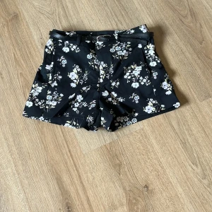 Blommiga shorts - Jag säljer dessa blommiga shorts från new yorker. De har fickor och en liten slits på vardera sida. De är i storlek 34 men skulle säga att de passar om man vanligt vis har  xs/ s.  Det finns även ett skärp. De är i väldigt bra skick då de knappt har blivit använda. Skriv till mig vid frågor. 
