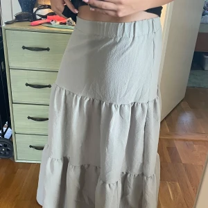 Lång kjol - En långkjol i fint skick. Grå blå och grön färg. Vet inte vart den är ifrån men jag är 164cm lång och passar perfekt skulle säga att storlek är XS