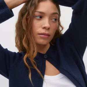 Mörkblå kofta från Gina Tricot - Mörkblå kofta från Gina Tricot med rund hals och en knapp framtill. Långärmad och ribbad vid muddar och halsringning. Perfekt att slänga över en t-shirt för en chill look. Materialet är mjukt och stickat, vilket gör den skön att bära.