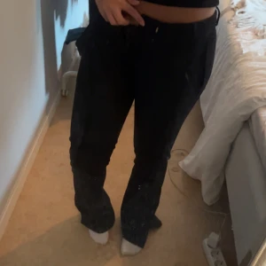 Svarta vida byxor från BikBok - Säljer ett par svarta byxor från BikBok i storlek lopp 34. Byxorna har en vid passform med slits nertill på benen. Perfekta om du gillar en trendig och avslappnad look. Materialet känns mjukt och följsamt.