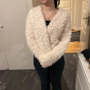 Beige fluffig teddyjacka - Supermjuk och fluffig teddyjacka i beige med långärmad design och avslappnad passform. Jackan har en öppen front utan knappar eller dragkedja och är perfekt för dig som gillar mysiga och trendiga plagg. Passar till jeans eller kjol för en chill look. Superskön❤️