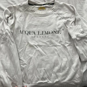 Vit sweatshirt från Acqua Limone - Vit långärmad sweatshirt från Acqua Limone med klassisk logga framtill och stor gul citron-tryck på ryggen. Inga fläckar och i bra skick.
