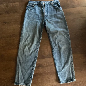Retero Blue Leroy  jeans från Woodbird - Säljer ett par klassiska blå jeans från Woodbird med raka ben och normal passform. Väldig bra skick, bara lite små trasiga i benen, men jag tycker det bara det ser snyggt ut. Inte använda på ett år och använda under endast en vinter säsong. Pris kan diskuteras vid snabb förhandling.