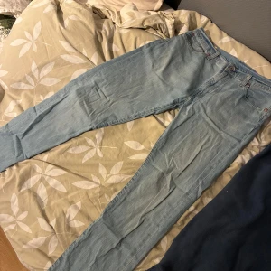 Levi's 512 ljusblå jeans W33 L34 - Säljer ett par Levi's 512 jeans i ljusblå tvätt. Klassisk femficksmodell med raka ben och normal passform. Jeansen har läderpatch bak i midjan och den ikoniska röda Levi's-taggen på bakfickan. Perfekta för en avslappnad och stilren look.