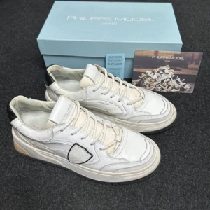 Vita sneakers från Philippe Model - Snygga vita sneakers från Philippe Model med svarta detaljer och snörning. Skorna har en stilren design med en robust sula och är perfekta för en casual look. Bara skor med kommer, bra skick men kan tvätta innan jag skickar dem. Storlek 41, passar 42 för fler bilder eller funderingar kom privat, tveka inte vid köp• PostNord och instabox funkar utmärkt 📬📬