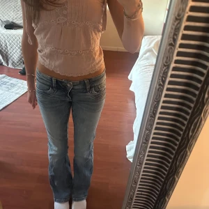 Ljusblå bootcut jeans - Säljer ett par ljusblå jeans med bootcut passform och låg midja. Jenasen är från Gina Tricot young och är i stl 146. Men för referens är jag 160 lång och bär oftast XS jeans.. Jeansen har klassiska fem fickor, bälteshällor och snygga slitningar framtill. Perfekta för dig som gillar en avslappnad och trendig look.