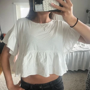Vit volangblus från Dilvin - Supersöt vit blus från Dilvin med volang nedtill och korta, vida ärmar💕