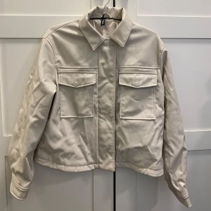 Beige skinnjacka - Skinnjacka med knappar och dragkedja ifrån divided/H&M. Använd fåtal gånger 