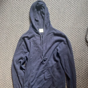 Marinblå cashmere hoodie John Henric - Snygg marinblå hoodie från John Henric i mjuk och lyxig cashmere. Tröjan har huva med snörning, lång ärm och en klassisk känguruficka framtill. Perfekt för dig som vill ha en chill och stilren look med extra komfort. Nypris 2500kr Mitt pris 699kr! Använd fåtal ggr, inga defekter.