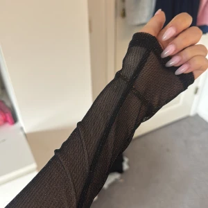 Svart glittrig fest topp - Säljer en svart glittrig topp med lång ärm och transparent material. Nästan aldrig använd då jag aldrig hittar något tillfälle att använda den, toppen funkar att ha på fest tillfällen eller tex nyår 💕