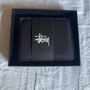 Stüssy plånbok - Svart plånbok från Stüssy i nyskick, aldrig använd. Köpt på Vinted. Pris kan diskuteras.
