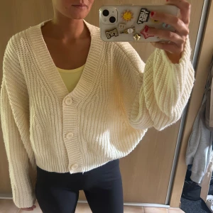 Beige stickad kofta från Weekday - Supermysig beige stickad kofta från Weekday i oversized modell. Koftan har bred ribbstickning, stora knappar framtill och långa ärmar