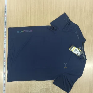 Blå Under Armour t-shirt i funktionsmaterial - Snygg marinblå t-shirt från Under Armour med diskret logga på bröstet och färgglad text på axeln. Gjord i ett lätt och snabbtorkande funktionsmaterial som passar perfekt till träning. Klassisk passform med korta ärmar och rund hals.