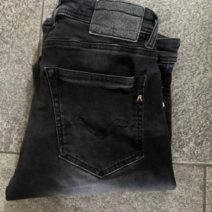 Replay jeans  - Säljer ett par svarta Replay Grover jeans i klassisk rak modell. Jeansen har snygga detaljer på bakfickan och diskret Replay-logga. Materialet är mjukt och stretchigt för extra komfort. Perfekta för dig som gillar stilrena och tidlösa jeans.