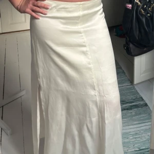 Vit långkjol  - Snygg vit långkjol med en liten slits, lågmidjad