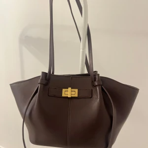 Vinröd väska Gina tricot  - Supersnygg och stilren vinröd väska med guldiga detaljer från Gina tricot i modellen ”midi long strap bag”❤️! (färgen syns bäst på tredje bilden från hemsidan), den är använd fåtal ggr men är fof i bra skick med endast lite slitage på både handtagen (syns på sista bilden)☺️ original pris 399kr !!