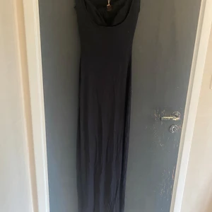 Svart långklänning från Skims XS - Supersnygg svart långklänning från Skims i modellen Soft Lounge Lace Tank Dress. Klänningen har en tight passform och är ärmlös. Aldrig använd, hund finns i hemmet
