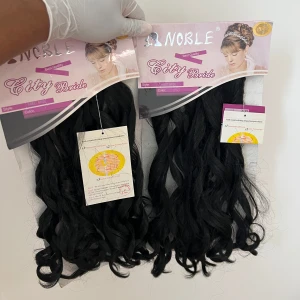 Noble City Bride svarta löshår - Två paket Noble City Bride löshår i färg 1 (svart). Långa, lockiga hårdelar med glansig finish, perfekt för att skapa volym och längd. Syntetiskt material, stil 'Sweet Bride'. Säljs i originalförpackning.