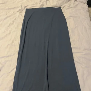 Mörkblå långkjol i bomull - Enkel och stilren mörkblå långkjol i mjukt bomullstyg. Kjolen har en rak och flowy passform som gör den superbekväm och lätt att matcha med olika toppar. Perfekt för dig som gillar minimalistisk stil.