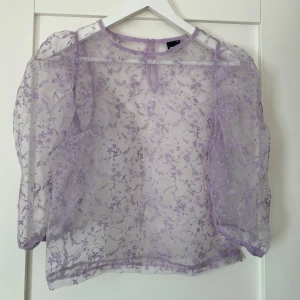 Lila blommig meshblus Gina Tricot - Superfin transparent lila blus från Gina Tricot med broderade blommor. I storlek 34. Använda ca 1 gång. 