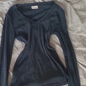 Elena gilbert tröja - Mörkblå långärmad tröja från Bon'A Parte med v-ringning och ribbad struktur. Skön och stretchig passform som sitter snyggt på kroppen. Perfekt för lager-på-lager och enkel att matcha med jeans eller kjol.