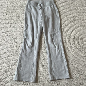 Grå bootcut mjukisbyxor från H&M - Snygga ljusgrå mjukisbyxor från H&M med bootcut-ben och bred, ribbad midja. Byxorna är i mjukt bomullsmaterial. 
