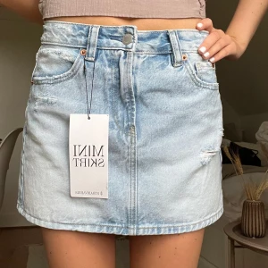 Ljusblå jeanskjol från Stradivarius - Säljer en snygg ljusblå jeanskjol från Stradivarius. Perfekt till sommaren!!!!