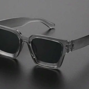 Svarta fyrkantiga solglasögon - Snygga solglasögon med transparent grå båge och svarta fyrkantiga glas. Riktigt trendig modell som ger en cool vibe till din outfit. Perfekt accessoar för att sticka ut i mängden.