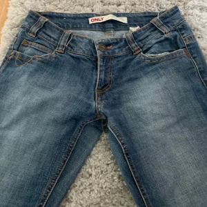 Blå bootcut jeans från ONLY (low rise) - Snygga blå jeans från ONLY med bootcut-modell och low midja. Klassisk femficksdesign, orange kontrastsömmar. Om ni har några frågor så bara fråga på💕