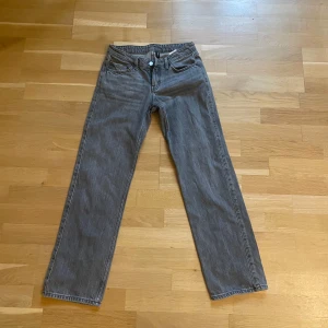 Grå raka jeans från Weekday - Säljer ett par grå jeans från Weekday med klassisk femficksdesign och raka ben. Jeansen har låg midja och är tillverkade i bomull med en snygg tvättad finish. Perfekta för en clean och avslappnad look.🩵