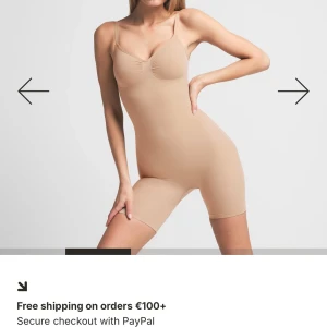 Beige shaping bodysuit med smala axelband - Snygg beige shaping bodysuit med smala axelband och sömlös design. Den har en tight passform och är tillverkad i stretchigt syntetmaterial som formar kroppen. Perfekt under kläder för en slät siluett och bekväm känsla hela dagen.