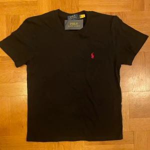Svart t-shirt från Polo Ralph Lauren - Helt ny svart polo Ralph lauren T-shirt i storlek M säljer den pga den är inte min stil fick den ett tag sedan, den är perfekt du till sommaren. Den är m däremot kan passa s. Den är helt ny och har alla tags kvar. Priset går att diskuteras vid snabb köp. Vid frågor är det bara att fråga. 