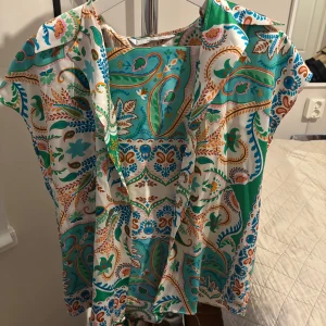 Färgglad skjorta och byxa från MANGO, M - Säljer både skjorta och byxa i ett färgglatt sett. Knappt använda. Byxorna kommer med ett skjärp som man tydligt ser på fjärde bilden