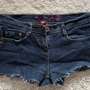 Mörkblå jeansshorts med fransig kant - Snygga mörkblå jeansshorts med låg midja