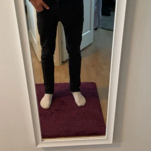 Svarta Replay Grover jeans - Tjena säljer nu ett par svarta Replay Grover jeans med storlekarna 30/32[modellen är 185cm och 70kg]. Jeansen har inga tecken på användning skick 10/10. De är en slim passform med klassisk femficksdesign och raka ben. Jeansen är tillverkade i stretchig bomullsdenim för extra komfort och har diskreta detaljer. Perfekta för dig som gillar stilrena svarta jeans. Priset är inte hugget i sten!