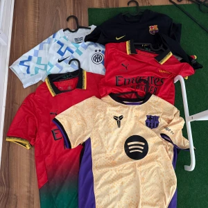 Flera fotbollströjor Nike, Puma, Barca, Inter - Säljer flera snygga fotbollströjor från Nike och Puma, bland annat Barcelona, Inter och Milan. Tröjorna är kortärmade och finns i färger som röd, svart, vit, blå, gul och lila. Några har mönster och klubbmärken, vissa med sponsorloggor. Perfekt för dig som älskar fotboll och vill ha stil på planen.