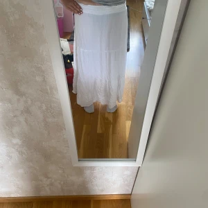 Vit tunn långkjol - Luftig vit långkjol med bred resår i midjan. Kjolen är perfekt för varma dagar. Enkel och stilren design som passar till många olika toppar. Priset kan diskuteras.