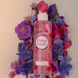 La Rive Crazy in Love Body & Hair Mist - Fräsch body & hair mist från La Rive i doften Crazy in Love. Flaskan är genomskinlig med rosa detaljer och blommigt tryck. Innehåller vitamin E och provitamin B5 för extra vård. Perfekt att spraya i håret eller på kroppen för en söt och fruktig känsla.