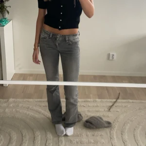 Grå bootcut jeans låg midja - Säljer ett par grå jeans med bootcut och låg midja. Jeansen har klassisk femficksdesign och är i ett mjukt denimtyg med snygg tvättad look. Perfekta för dig som gillar en avslappnad men trendig stil. Har vanligtvis 32-34 och dessa sitter bra, på gränsen till för korta på mig som är 174