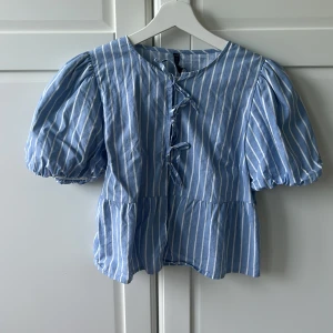 Blåvit randig blus  - Supersöt blus i blått och vitt med puffiga korta ärmar och knytning framtill 💙 Aldrig använd men jag har lyckats dragit av lappen. Fler bilder kan fixas