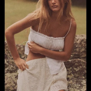 Vit broderad linnetopp med knappar - Superfin vit linnetopp med tunna axelband, broderade detaljer framtill och knappar längs hela framsidan. Endast använd ett par gånger.