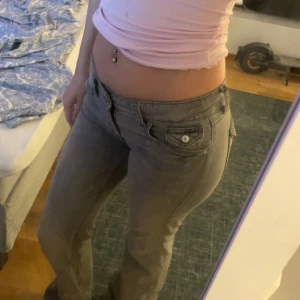 Grå bootcut jeans från Gina Tricot - Snygga grå jeans från Gina Tricot med bootcut passform och låg midja. Jeansen är i storlek 170 kommer inte till användning annars kanske byta mot nått Nelly par men de är lite sönder trampat där nere vid fötterna men annars fina😘 köparen står för frakt💗pris kan diskuteras vid snabb affär. 