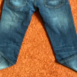 Blå jeans med slitningar - Säljer ett par klassiska blå jeans med snygga slitningar och tvättade detaljer. Perfekta för en avslappnad och cool stil. Jeansen har raka ben och normal passform.