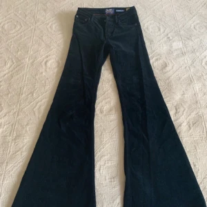 Mörkblå manchester Pow Flare byxor Crocker - Säljer ett par mörkblå manchesterbyxor från Crocker, modell Pow Flare. Byxorna har riktigt utsvängda ben och klassisk femficksdesign. Perfekta för dig som gillar retrovibbar och vill sticka ut med en cool siluett.