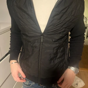 Svart cardigan från J.Lindeberg - Säljer min sjukt snygga och sköna cardigan från J.lindeberg. Sjukt bra skick, endast lite nopprig men det går lätt ta bort! Nypris ligger på 3200kr, säljer för enbart 1500kr, priset ej hugget i sten, bara att höra av sig vid fler frågor! Mvh Elton!