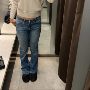 Bootcut jeans blå - Säljer ett par jeans i blå denim med bootcut passform. Jeansen har normal midja, fem fickor och dragkedjegylf. Perfekta för dig som gillar en tidlös look med lite utsvängda ben. Materialet är slitstark bomullsdenim.
